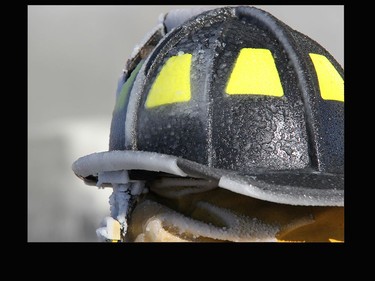 Firefighters not only had to battle the fire, but also the cold as evidenced by the amount of ice caked to this fire helmet from the water from the fire hoses.