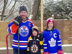 Mark Rossetto with his sons, nine-year-old Brett and 12-year-old Nik, at the family's backyard rink in Sault Ste. Marie. SPECIAL TO SAULT THIS WEEK