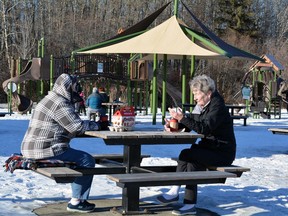 Val Hawkins, left and her friend Cindy McCoy, both from Spruce Grove, enjoy the mild weather and a visit over a Tim Horton's coffee and timbits at Rotary Park in Stony Plain on Saturday. A return to more normal winter temperatures is expected when a cold front arrives this weekend. Kristine Jean