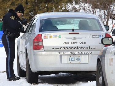 An Ontario Provincial Police officer photographs a cab from Espanola that was pulled over by police in Lively, Ont. on Thursday January 21, 2021. John Lappa/Sudbury Star/Postmedia Network