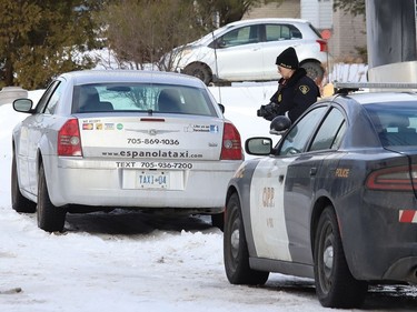 An Ontario Provincial Police officer photographs a cab from Espanola that was pulled over by police in Lively, Ont. on Thursday January 21, 2021. John Lappa/Sudbury Star/Postmedia Network