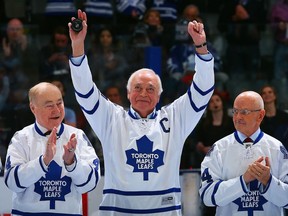 George Armstrong gestures to fans in Toronto during a night to celebrate Maple Leafs greats. He is flanked by Red Kelly and Dave Keon. Getty Images