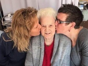 Terri Sakach (left) and Lynn Bailey give their mom Shirley a kiss before COVID prevented them from physical contact. .TP.jpg