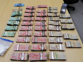 A police photo shows cash and drugs seized recently during a Project Renewal search.