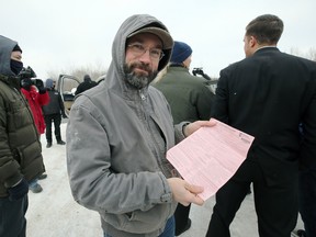 A man displays a ticket he was given by Manitoba Justice officials for disobeying public health orders outside Church of God, south of Steinbach, Man., on Sunday, Nov. 29, 2020. Kevin King/Winnipeg Sun/Postmedia Network