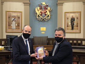 Kingston Mayor Bryan Paterson receives a copy of Yara's Spring from Kirkus Kirkus Best Book List author Jamal Saeed of the city in December 2020. Saeed used his experiences as a Syrian refugee to collaborate with well known Canadian YA writer Sharon McKay in writing the book.  
Supplied by Sam MacLeod