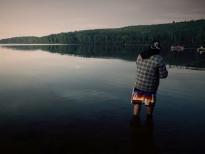 A man fishes in Moose Lake in this screenshot from a video, produced by the Fort McKay First Nation, explaining the site's importance to the community.