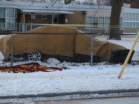 A car covered by tarps sits in the school yard at Hanna Memorial Public School in Sarnia. City police said Ontario's Special Investigations Unit is investigating a fatal single-vehicle crash..