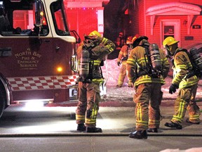 Firefighters prepare to enter a burning building on McIntyre Street East Saturday morning. 
PJ Wilson/The Nugget