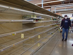 A shopper walks past a bare shelf as people stock up on necessities Thursday at a grocery store in Austin, Texas.  Joe Raedle/Getty Images