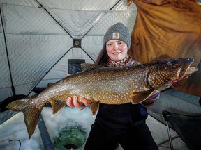 Erin Cressey, from Ponoka, in an ice fishing hut, poses with a lake trout she caught during the Cold Lake Fishing Tournament over Family Day weekend.