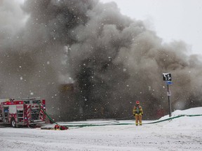 A North Bay firefighter is seen on Fisher Street, Monday morning, where a fire engulfed a Midas shop near the corner of Main Street East. Michael Lee/The Nugget