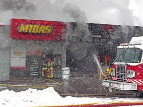 North Bay firefighters tackle a blaze, Monday morning, at the Midas shop on the corner of Main Street East and Fisher Street. Michael Lee/ The Nugget