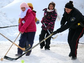 Const. Lyndsey Pilkington participates in a ball hockey game for recent immigrants to Sault Ste. Marie. Photo taken near The Machine Shop on Huron Street during Ontario Winter Carnival Bon Soo in Sault Ste. Marie, Ont., on Saturday, Feb. 4, 2017. (BRIAN KELLY/THE SAULT STAR/POSTMEDIA NETWORK)