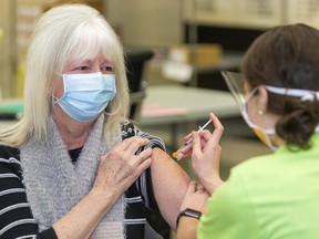 Anne Doherty of Middlesex, a essential care giver to her two parents receives a COVID-19 vaccination from public health nurse Hannah Currie at the Caradoc community centre in Mt. Brydges. Mt. Brydges is the site of a new vaccination centre set up by the Middlesex London Health unit, that opened on Feb. 18. Mike Hensen/Postmedia Network