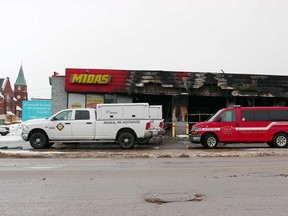 Investigators are pictured, Tuesday, at the downtown Midas in North Bay, located at the corner of Main Street East and Fisher Street, after a fire broke out at the shop, Monday morning. Michael Lee/The Nugget