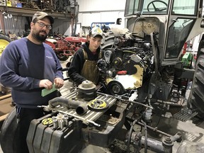 Supervisor Aaron Roth and Listowel District Secondary School student Aaron Schultz complete a custom engine swap on a tractor last fall at Roth Farm Service during a co-op placement as an agricultural equipment technician. Submitted photo