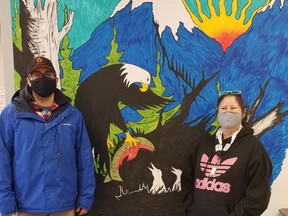 Dario (left) and Cece Boersen in front of a mural, by Russell Cardinal, inside Cold Lake's new warming centre. PHOTO BY TANYA BOUDREAU
