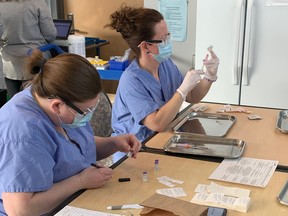 At Wednesday’s clinic for Marianhill staff and essential caregivers, Pembroke Regional Hospital  pharmacy technicians Krista Fraize, left, and Amy Warlich, were on hand to pre-load the vaccine doses for those administering the vaccine.