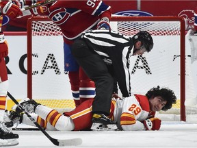 Linesman David Brisebois tries to help out Dillon Dube of the Calgary Flames during the second period at the Bell Centre on Saturday, Jan. 30, 2021.