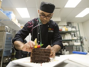 Chef Buddhika Chandrasekara decorates a triple layer chocolate cake with handmade candy decorations at Surekhas On The Snye, in Fort McMurray Tuesday April 2, 2019. Photo by David Bloom