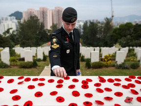 A Canadian armed forces member places a poppy over the Altar of Remembrance following the Canadian Commemorative Ceremony honouring those who died during the Battle of Hong Kong and the Second World War in Hong Kong's Sai Wan War Cemetery on Dec. 4, 2016.