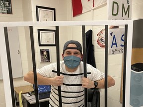 A teacher at St. John Paul II sits behind bars as part of a "throw your teacher in jail" school fundraiser. Photo supplied.