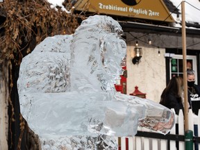 Shoppers pass the Boardwalk Ice On Whyte ICE AND THE CITY Sculpture TourÕs carving by Mark Berge and Cliff Vacheresse at Sherlock Holmes Pub in Edmonton, on Friday, Feb. 19, 2021. Photo by Ian Kucerak