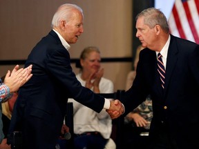 Democratic 2020 U.S. presidential candidate and former Vice President Joe Biden shakes hands with former Iowa Governor Tom Vilsack during a campaign event in Newton, Iowa, U.S., January 30, 2020. (REUTERS/Mike Segar/File Photo)