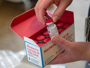A person unpacks a special refrigerated box of Moderna Covid-19 vaccine.