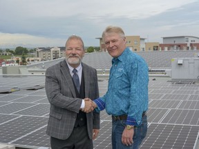 Mayor Peter Brown poses with Erwin Kantwerg among the new solar panels atop Genesis Place on Wednesday, July 10, 2019.