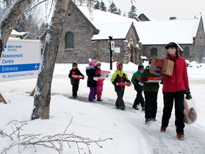 Kat Weib, Success Coach with Right from the Start, a Mental Health Capacity Building at Banff Elementary School, walks with her group of six students to deliver a Tim Horton's donation and the appreciation coffee sleeves and artwork on Friday morning on Jan 29. Items were dropped at the hospital's back service door to safely receive the treats in a contactless way, along with Thank You Letters, separately as these items have all needed to quarantine in a ziplock bag for the past week. Photo Marie Conboy/ Postmedia.