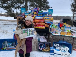 Dee Waite, of Belleville, holds her rescue dog Kinslee and a framed photo of Cajun. For the third straight year, Waite celebrated her birthday by asking friends and family to donate food, toys or accessories to the Quinte Humane Society. SUBMITTED PHOTO