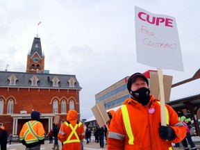Belleville public works employee Josh Clark and fellow members of the Canadian Union of Public Employees rally outside city hall late Wednesday afternoon. The city and CUPE Local 907 reached a tentative agreement early Friday.