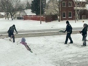 Two Brantford Police officers stopped to help children shovel snow from the driveway of their Brantwood Park home on Tuesday morning in Brantford, Ontario.