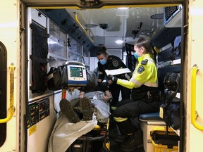 Brant Brantford paramedics Emily McHugh (standing) and Brianna Brick demonstrate how they can use a heart monitor on a patient suffering a heart attack. Their colleague, paramedic Jordan Ely, served as the patient for the photo.
