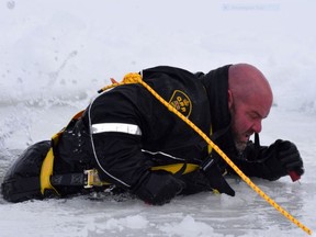 OPP Cst. Sean McCaffrey demonstrates self-rescue techniques for falling trough ice at Lower Reach Park in Smiths Falls. (SUBMITTED PHOTO)