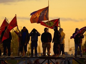 Protesters stand on a barricade re-erected with part of a hydro tower dropped across Argyle Rd. in Caledonia on May 23, 2006.