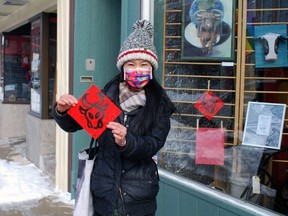 Raquell Yang, organizer of the Year of the Ox Art Show, part of the Grey Bruce Lunar New Year celebration, holds up one of the red ox signs that mark the locations of the art show in downtown Owen Sound. DENIS LANGLOIS