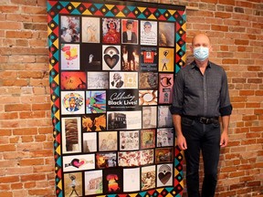 Thames Art Gallery curator Phil Vanderwall displays the Celebrating Black Lives: Community Quilt Project, comprising of artwork by 35 participants. The quilt is on public display at ARTspace's Window Gallery throughout Black History Month. (Ellwood Shreve/Chatham Daily News)