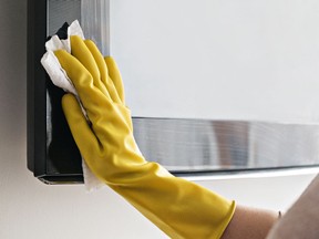 Mujer limpiando la televisión con paños húmedos y usando guantes amarillos durante el coronavirus, covid 19 cuarentena. Mantener la higiene en el hogar, limpiar el polvo y las bacterias, limpiar los virus de la televisión.

Not Released