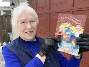 Mitchell's June Demerling holds a copy of her childen's book, R-U-N (An Adventure), she published late last year. ANDY BADER/MITCHELL ADVOCATE