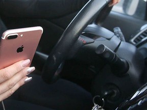 A motorist is on their phone in this Postmedia file photo. (Postmedia Network)