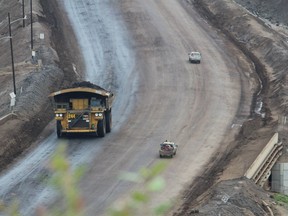A heavy hauler drives past smaller trucks near the entrance of Suncor Energy's North Steepbank Mine, located north of Fort McMurray, Alta., in this 2014 file photo. Vincent McDermott/Fort McMurray Today/Postmedia Network  ORG XMIT: nghLN4_CiB4tozteTmZk
