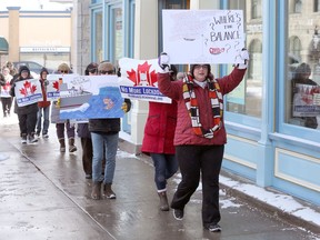 A group of approximately 16 demonstrators carried signs through downtown Kingston in a show against provincewide lockdown measures on Saturday.