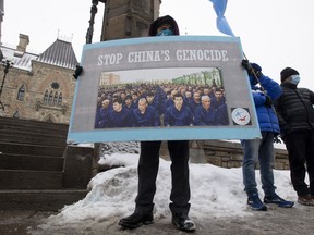 Protesters gather outside the Parliament buildings in Ottawa on Monday, Feb. 22. Parliament overwhelmingly supported an opposition motion calling on Canada to recognize China's actions against ethnic Muslim Uighurs as genocide.