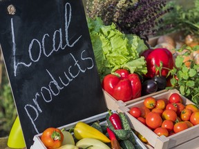 Counter with fresh vegetables and a sign of local products