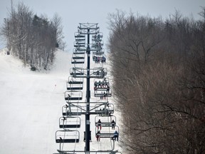 Skiers and boarders ride up the Silver Bullet chairlift on opening day at Blue Mountain Resort on Saturday, Dec. 19, 2020.