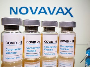 Vials and medical syringe are seen in front of Novavax logo in this illustration