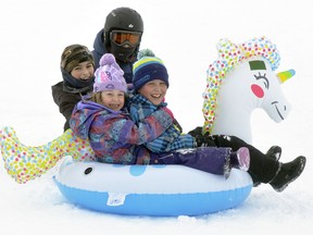 The smiles and giggles were obvious as Matteo Valentino (left), 11; Grace Linton, 6; Marco Valentino (in helmet), 8 and Miles Linton, 8, all of Mitchell soar down the Mitchell Lions Pool hill on Jan. 29. They weren't the only ones enjoying the outdoor fun, as the hill proved a popular place all weekend. ANDY BADER/MITCHELL ADVOCATE